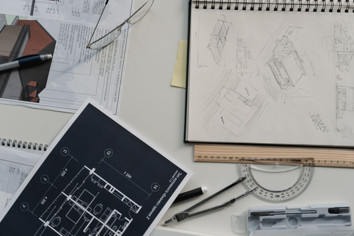 Architect reviewing a building floor plan on a laptop at a desk