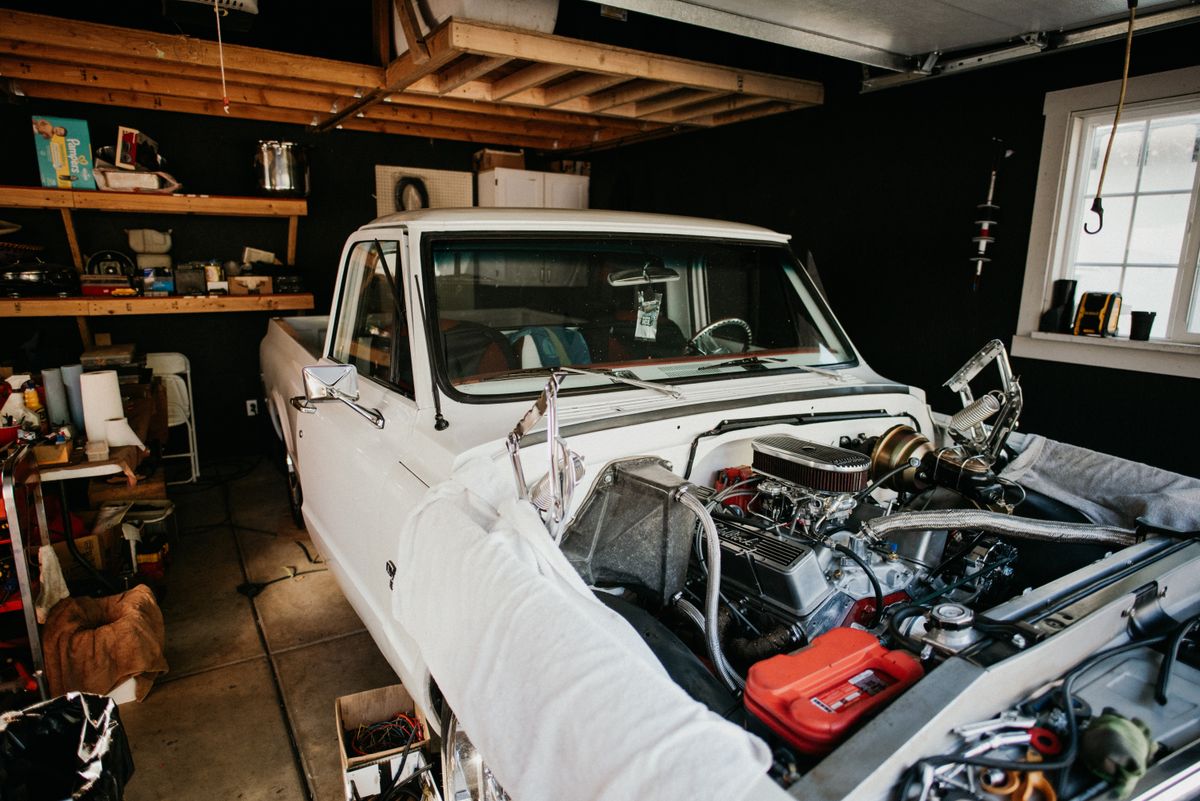 Classic pickup truck undergoing bodywork restoration in a garage workshop