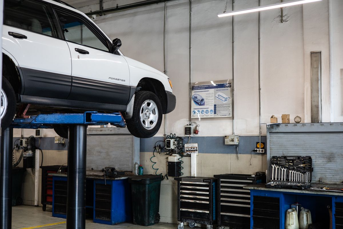 Car undergoing a maintenance check-up in a modern automotive repair bay