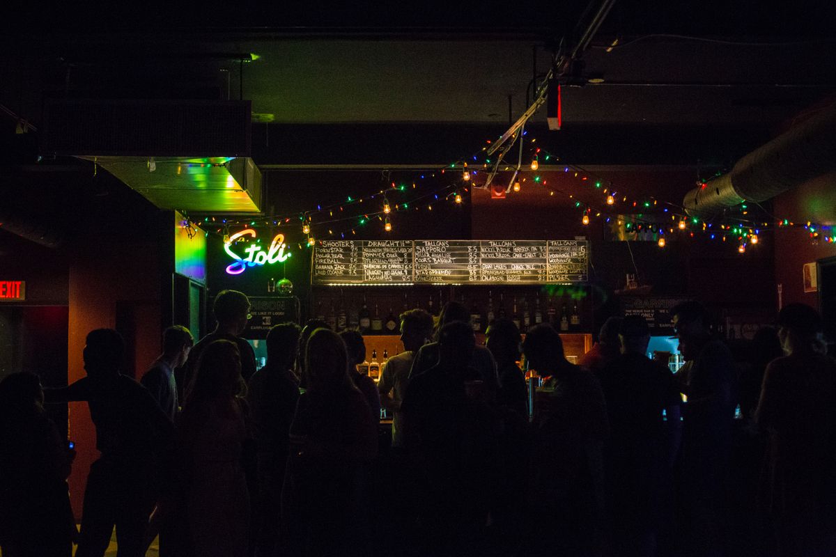 Guests seated at a dimly lit bar counter in Edinburgh at night
