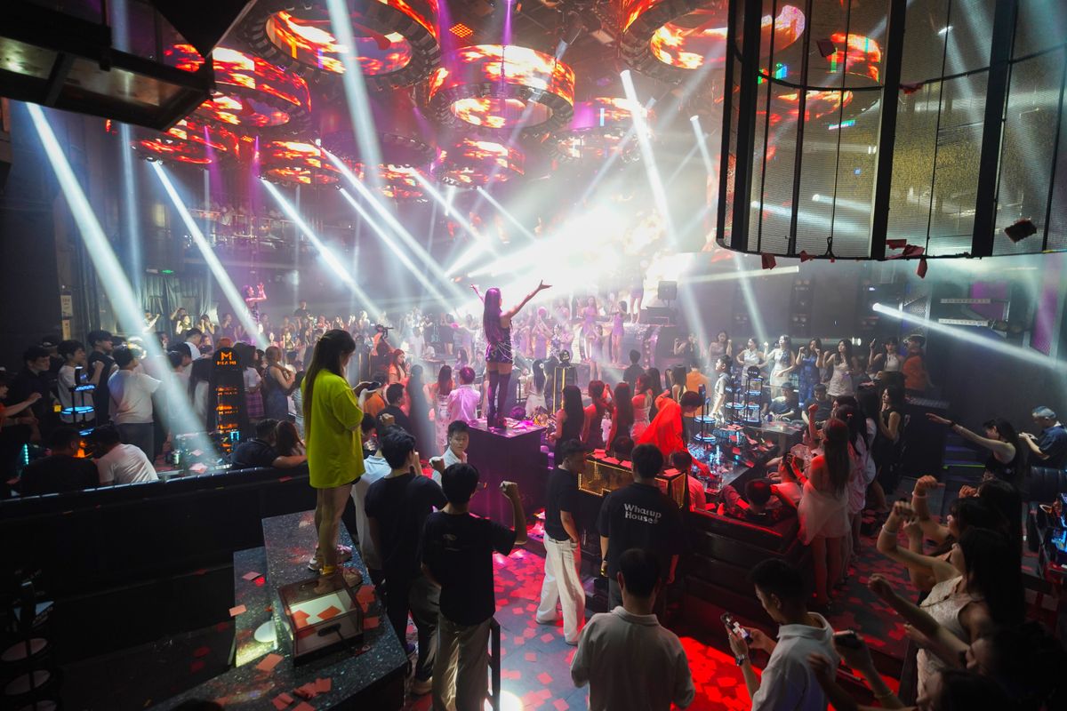 Nightclub dance floor with vibrant coloured lighting and a crowd