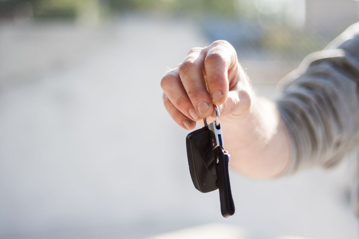 Rental agent handing over car keys to a customer at a hire desk
