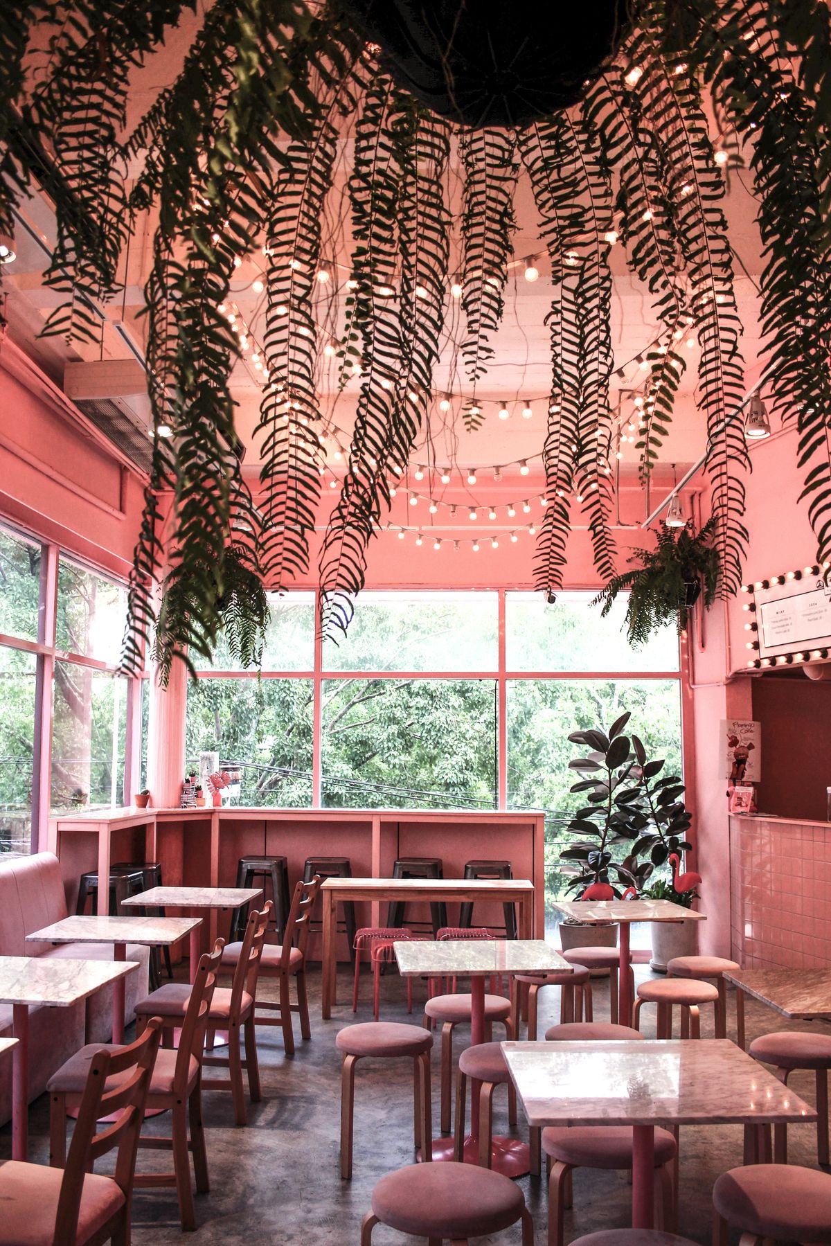 Bright cafe interior with plant decor and inviting table seating for customers