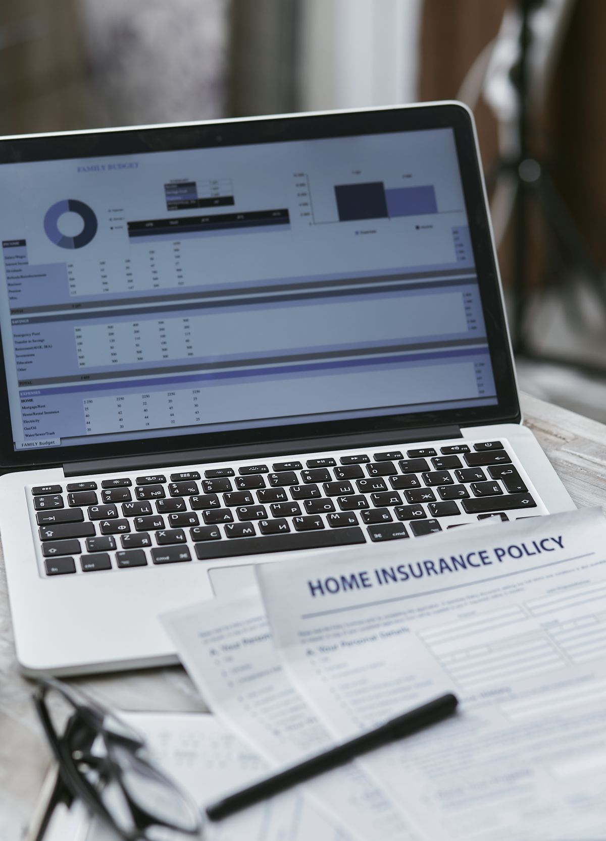 Business insurance policy documents and laptop on an office desk