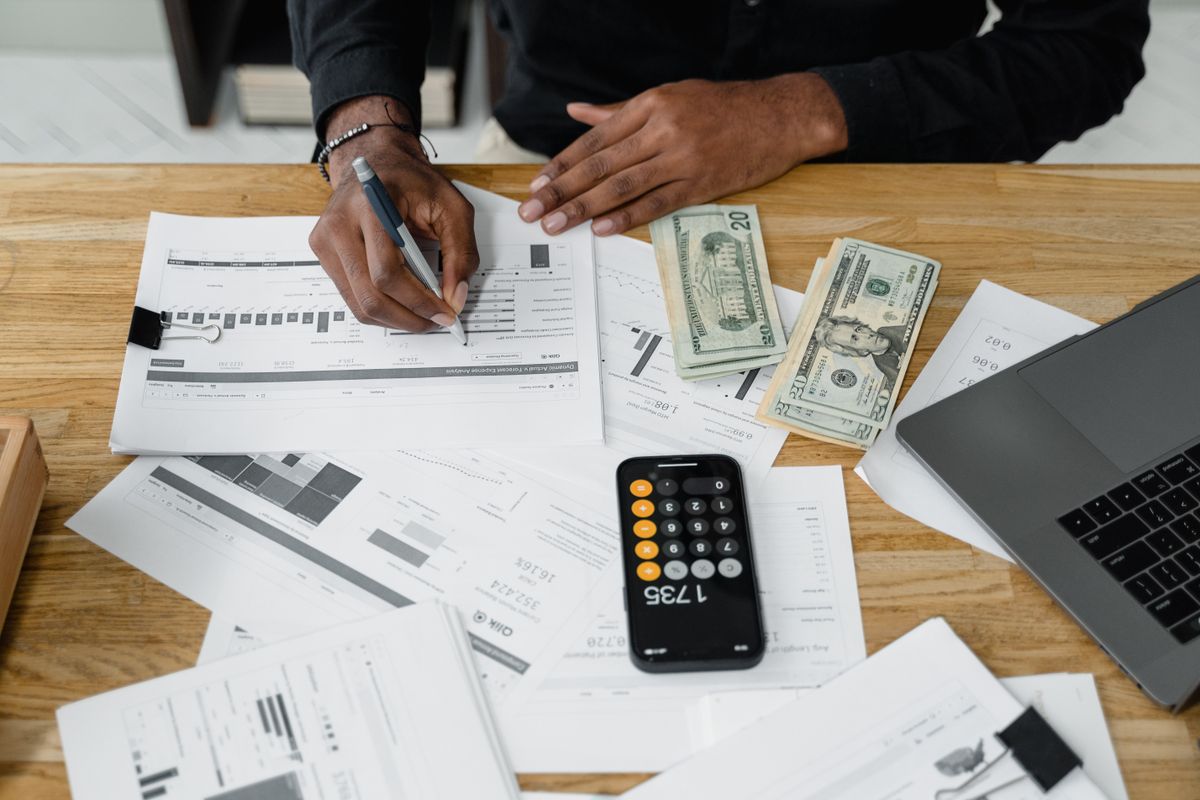 Close-up of an accountant using a calculator alongside tax documents and spreadsheets
