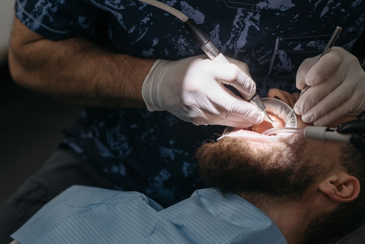 Close-up of a dental hygienist cleaning a patient's teeth in clinic