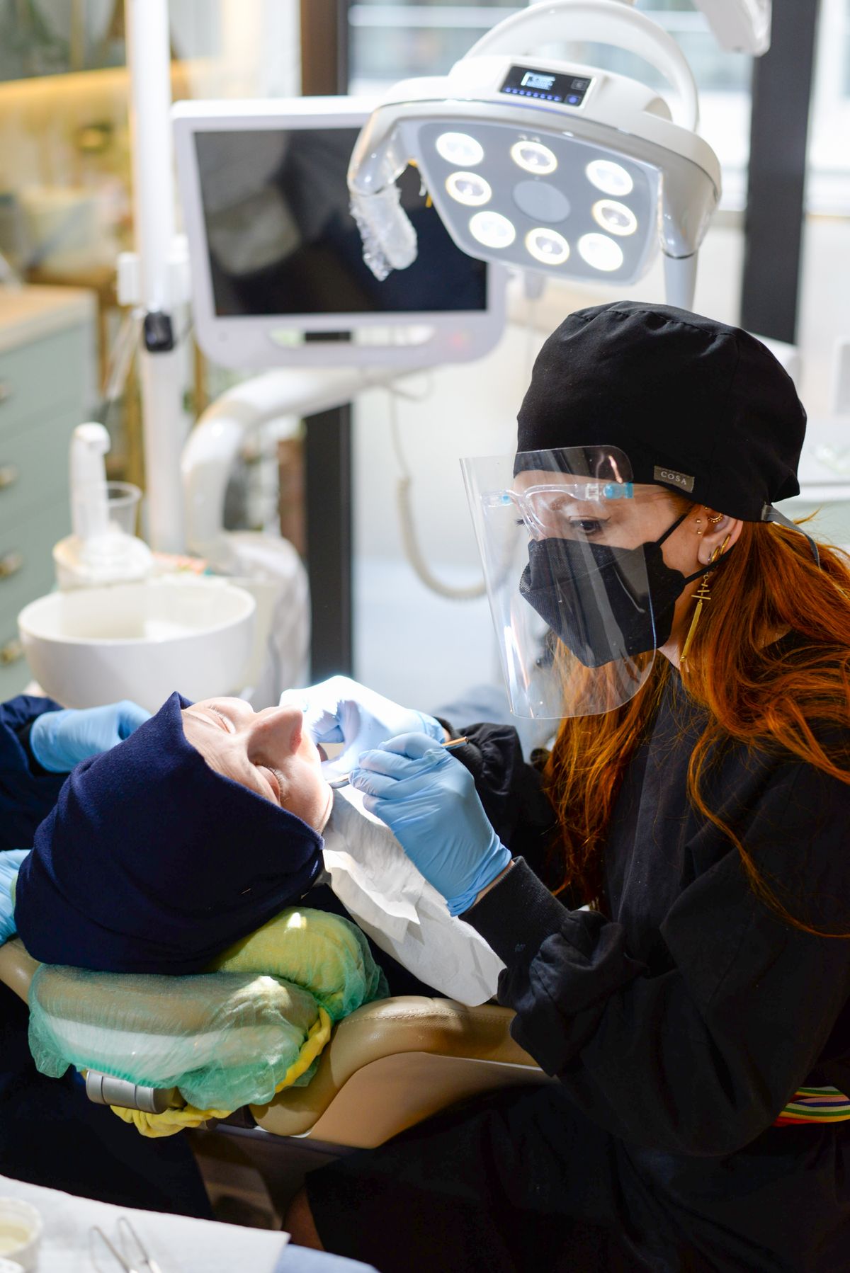 Dentist examining a patient during a routine dental clinic appointment