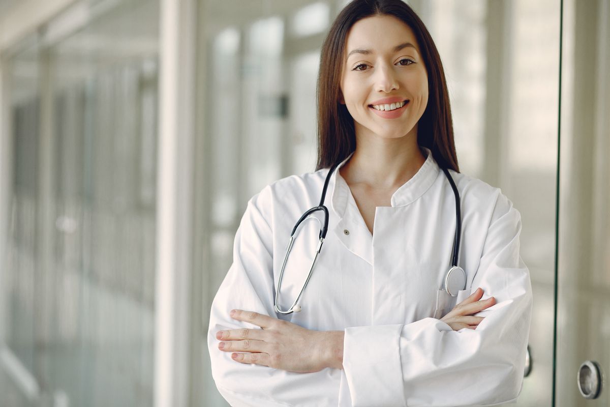 Doctor in medical uniform with stethoscope standing in a clinic corridor