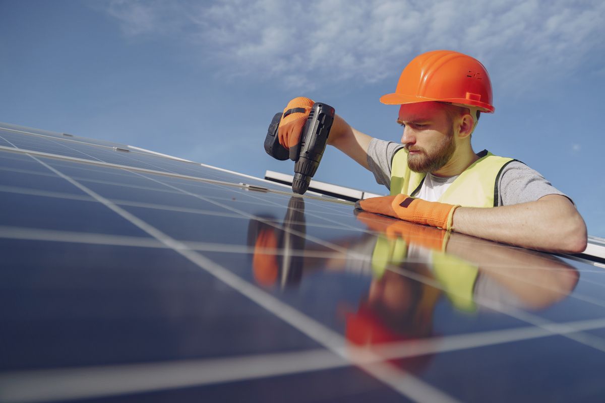 Electrician installing a solar panel as part of a domestic rewiring and renewables job