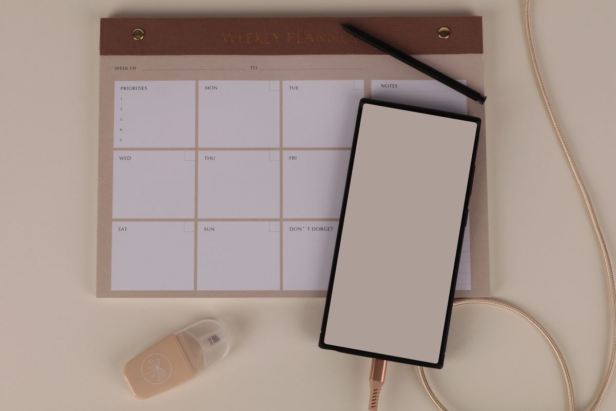 Event planner working at a desk with a weekly planner, coordinating bookings and client timelines