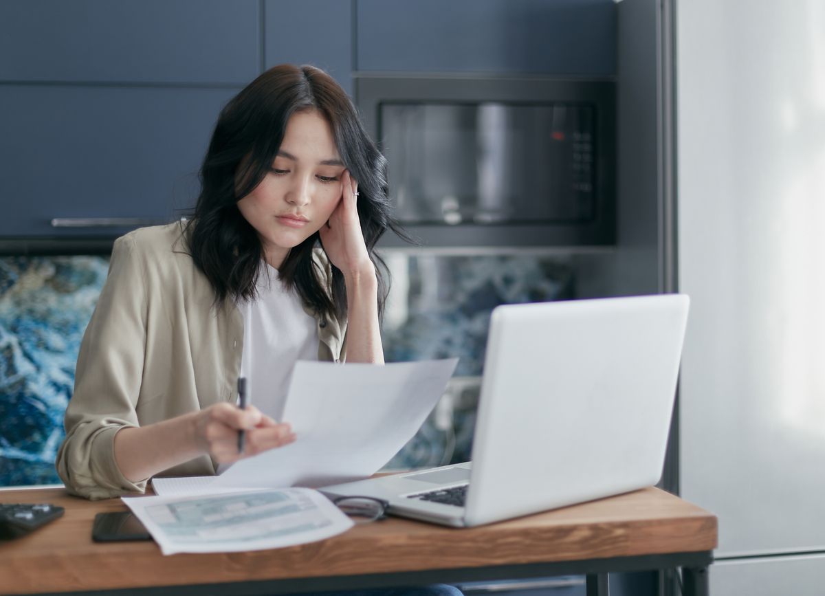 Advisor pointing to charts and graphs on paper documents while discussing a financial plan with a client