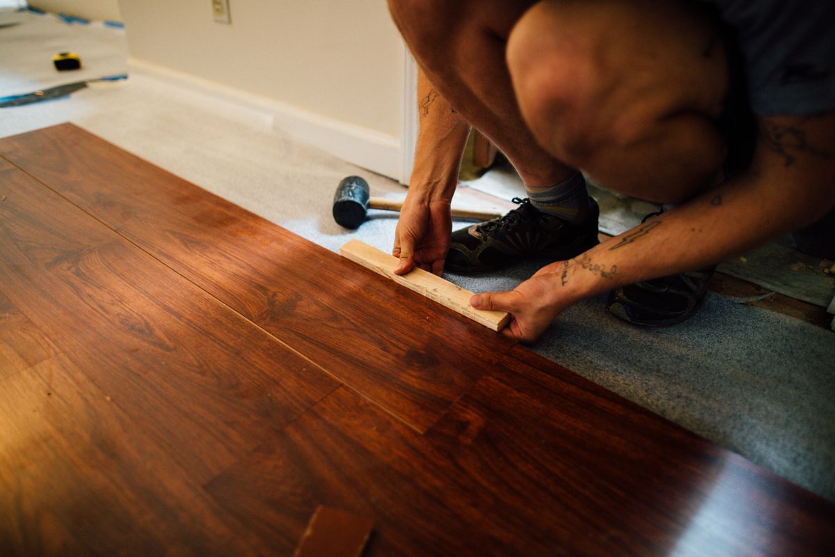 Flooring contractor installing laminate planks during a home renovation