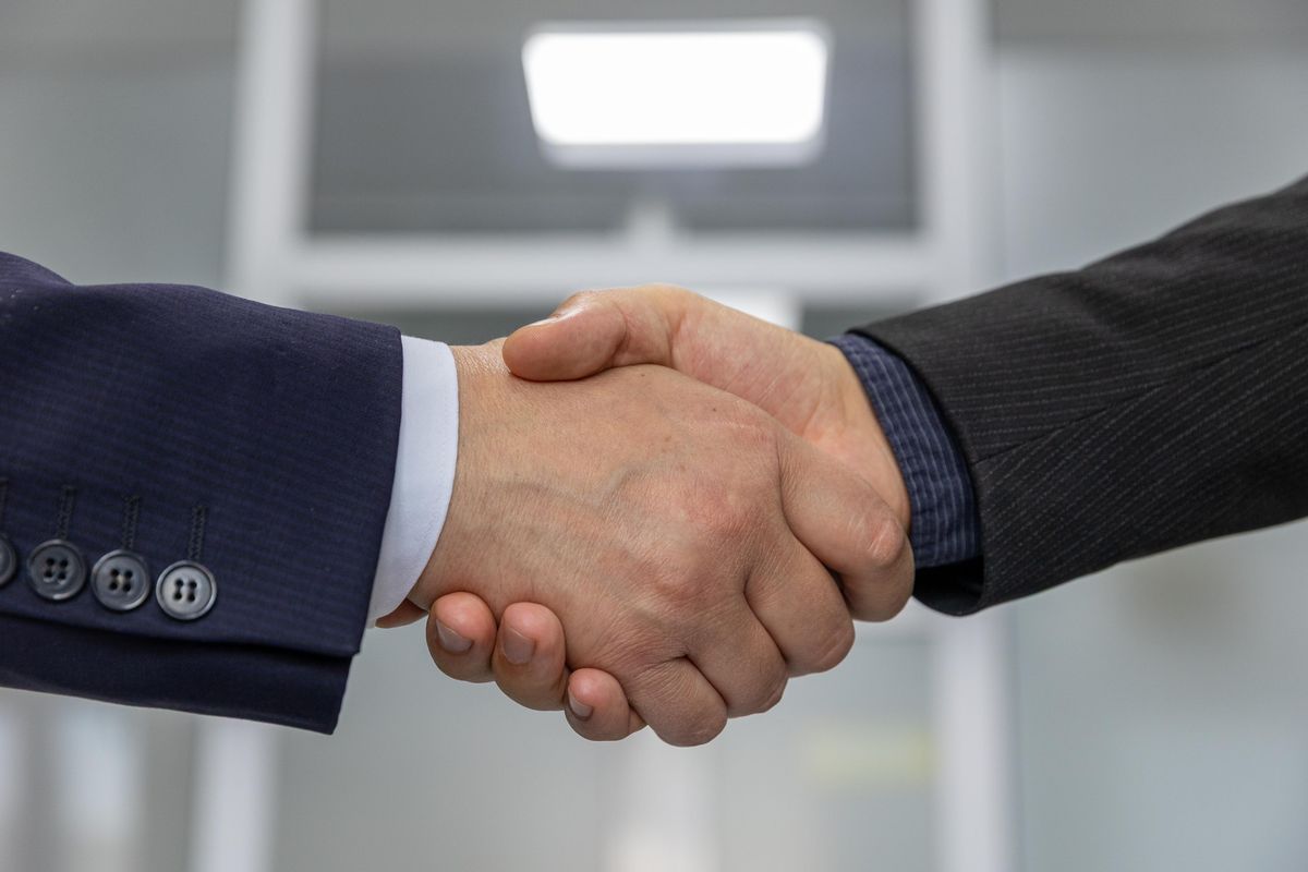 Two business partners shaking hands after agreeing terms on a new franchise territory