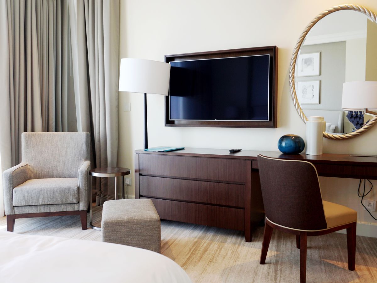 Well-appointed modern hotel bedroom with city view, the kind guests search for online