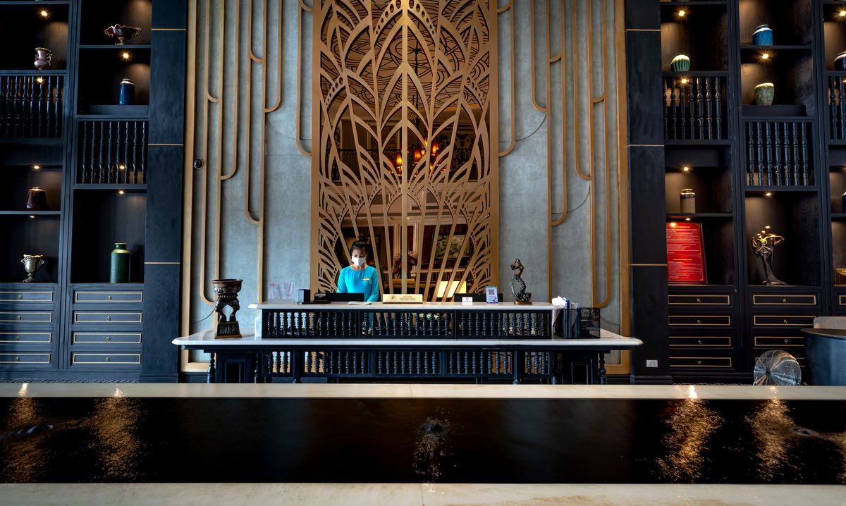 Hotel receptionist welcoming a guest at the front desk