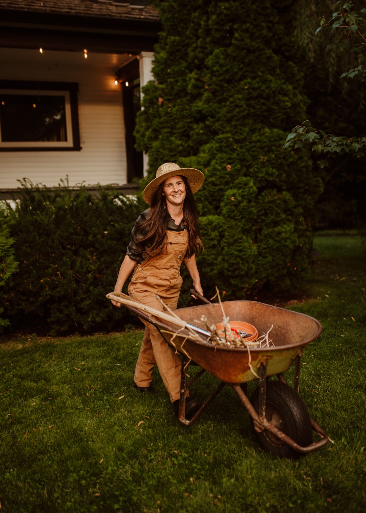 Landscaping crew member pushing a wheelbarrow across a garden during a project