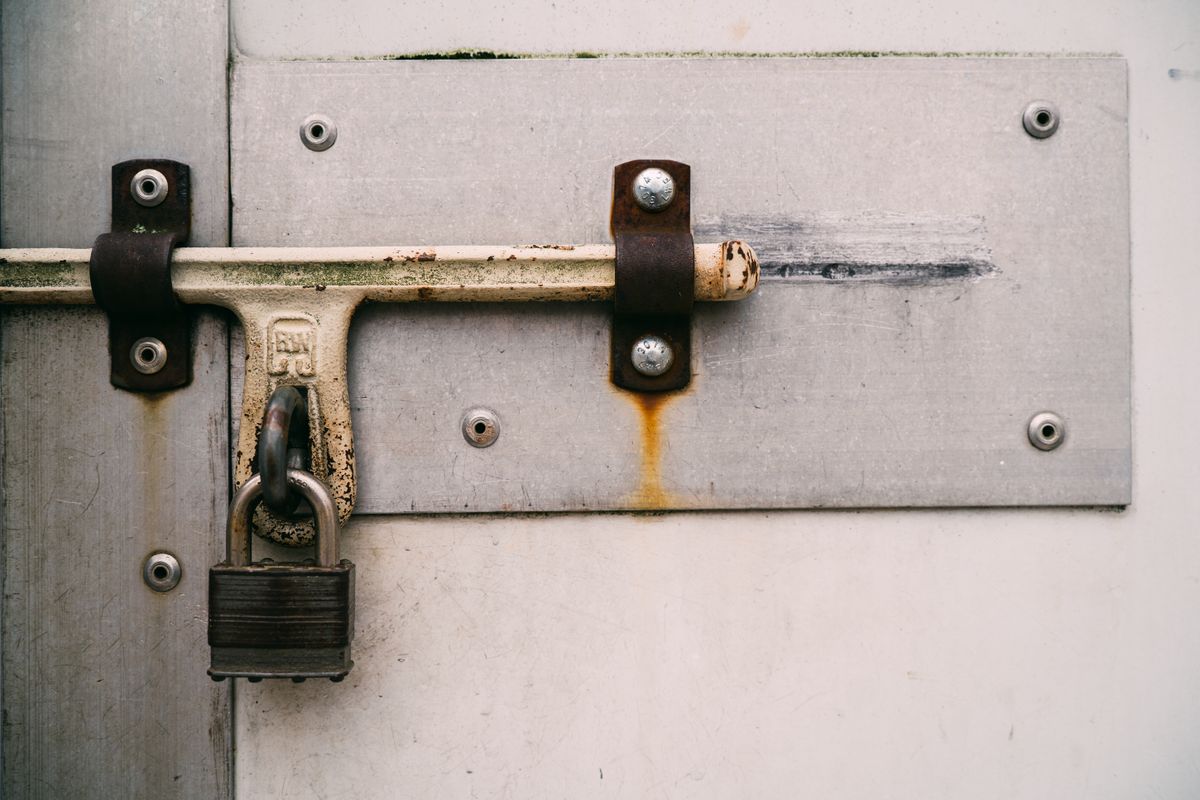 Padlock securing a closed metal door, representing commercial and property security work