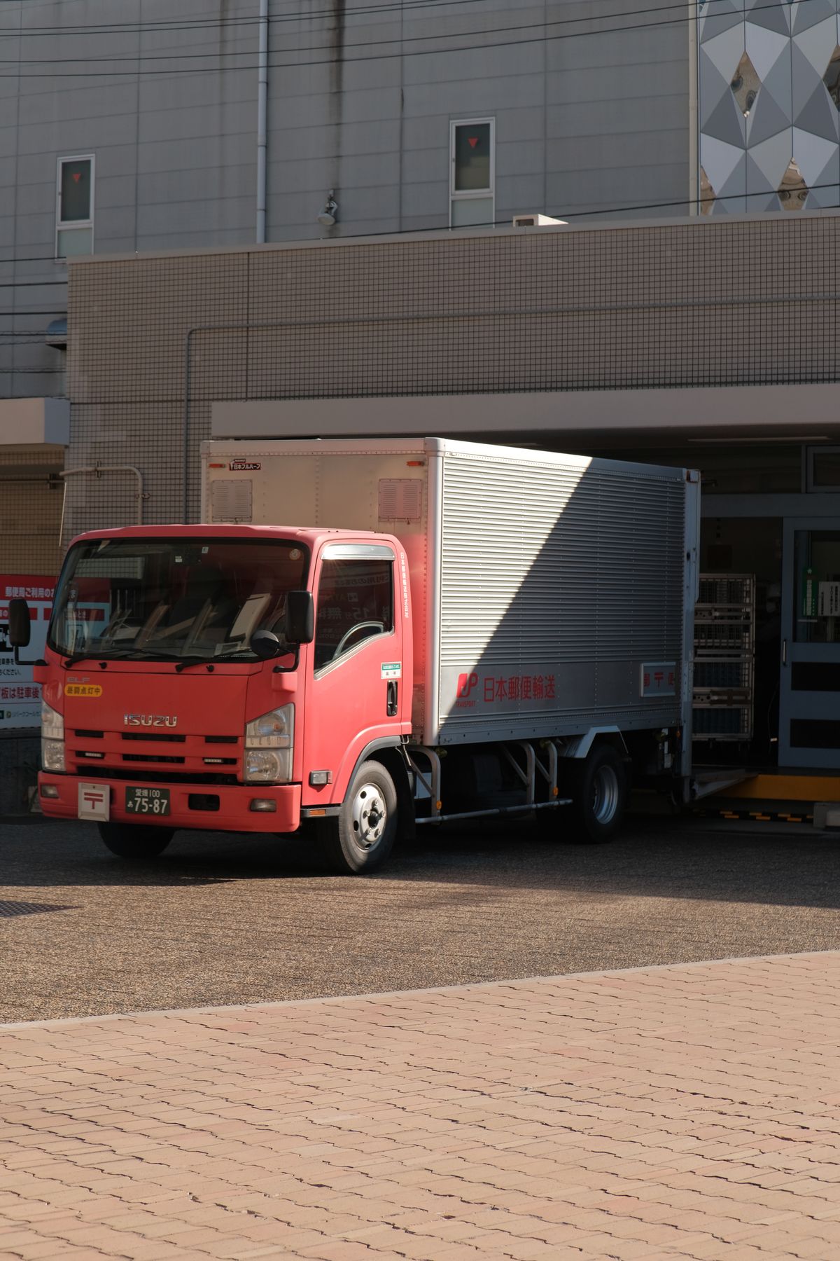 Delivery truck unloading pallets outside a logistics warehouse