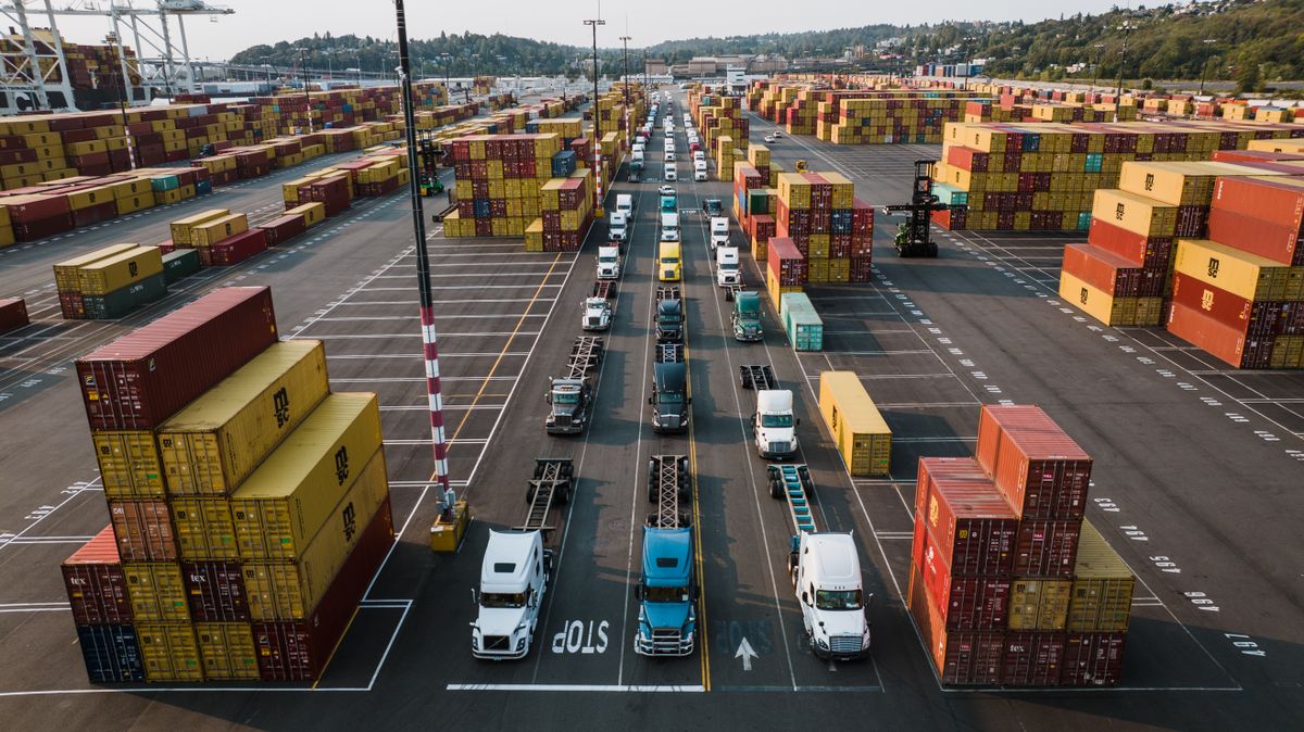 Haulage trucks and shipping containers parked at a freight depot