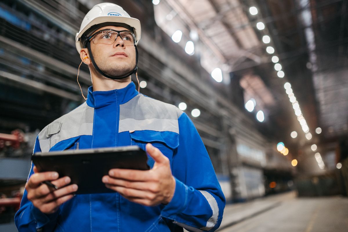 Industrial worker using a tablet to monitor production on a factory floor