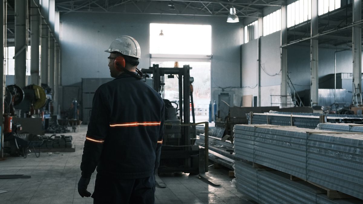 Industrial worker in a modern manufacturing facility overseeing operations