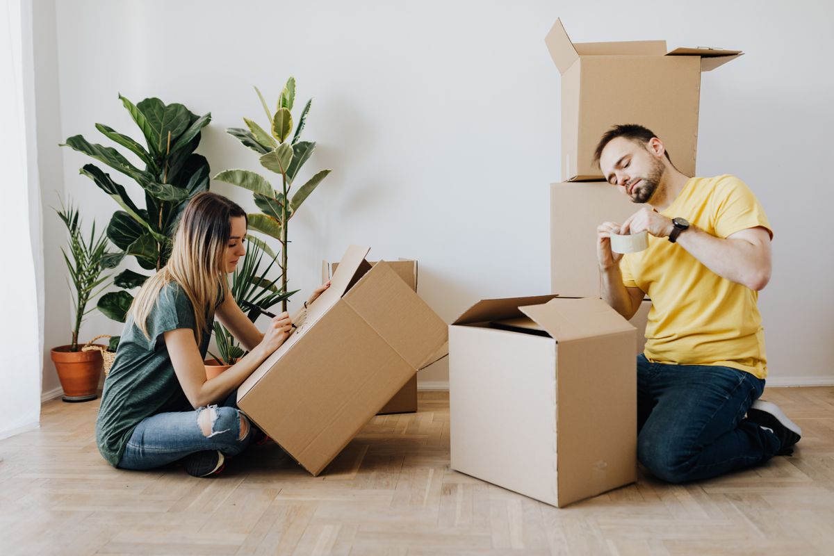 Couple packing belongings into carton boxes ahead of a house move