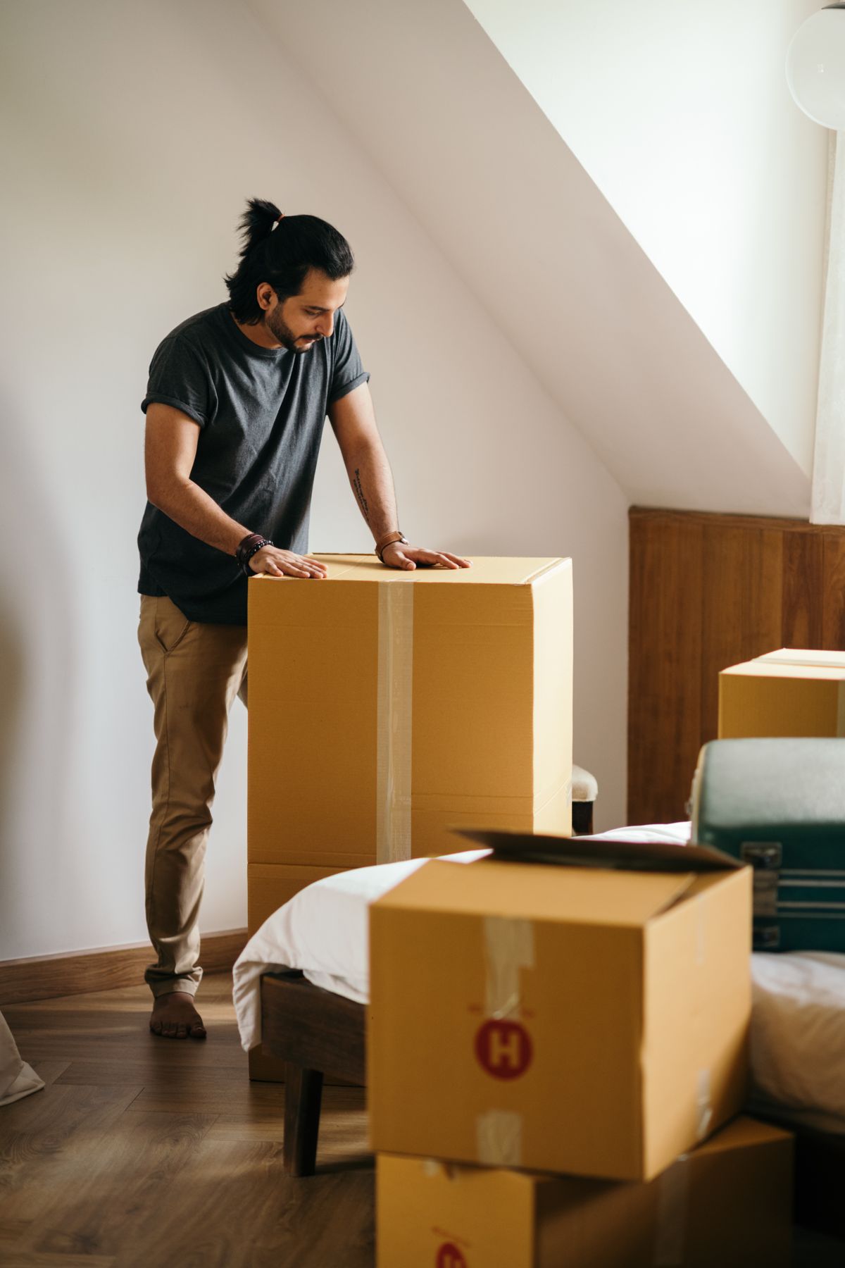 Man packing cardboard boxes at home before a removal