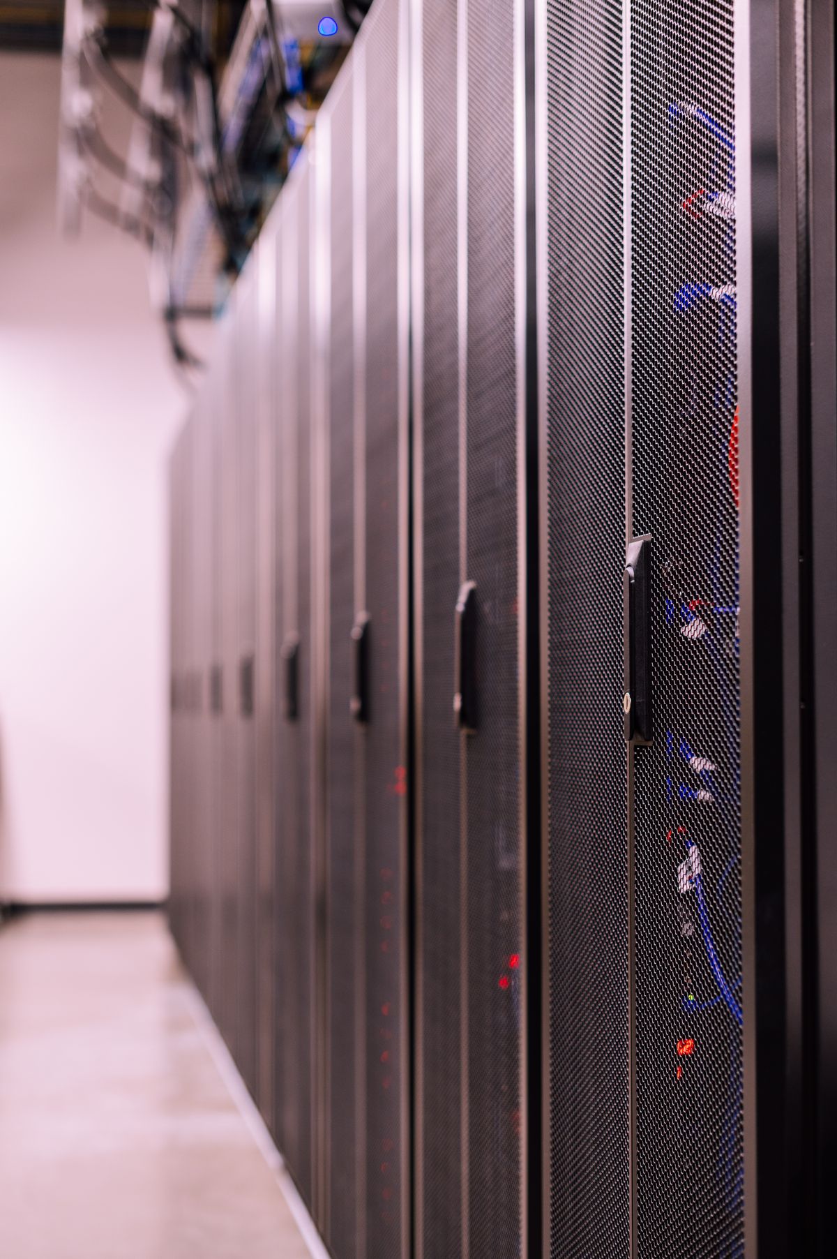 IT support technician working in a server room checking network equipment for a managed services client