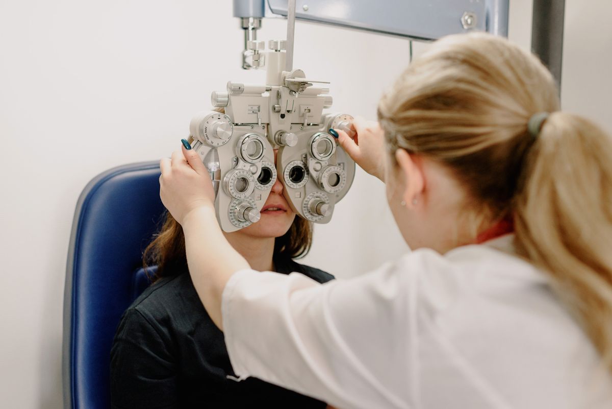 Ophthalmologist checking a patient's vision using a slit lamp in clinic