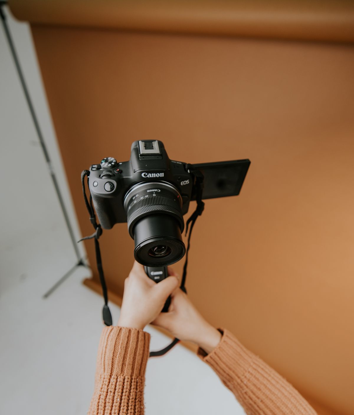 Photographer holding a camera in a studio setting