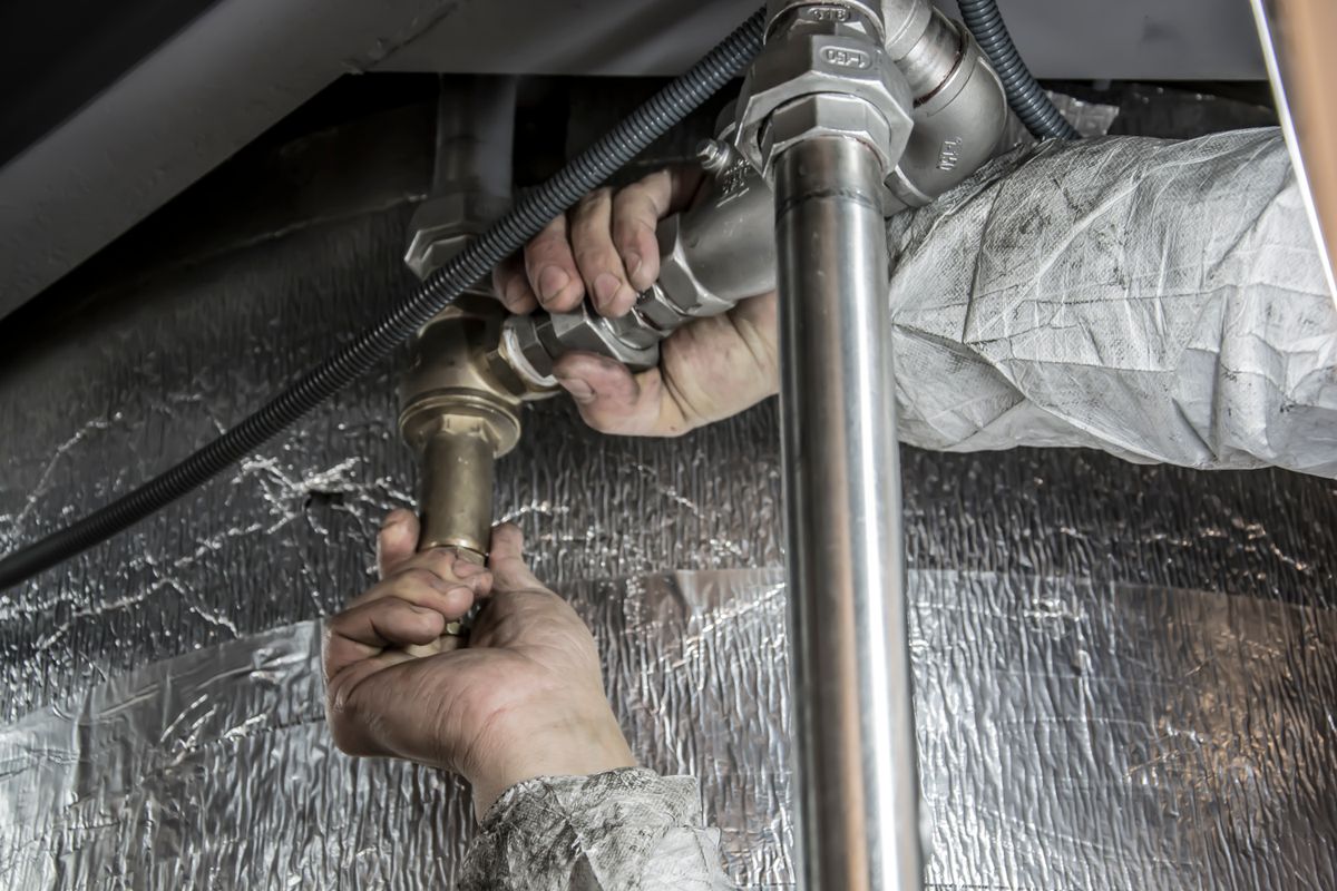 Plumber installing and fitting copper pipe fittings on site