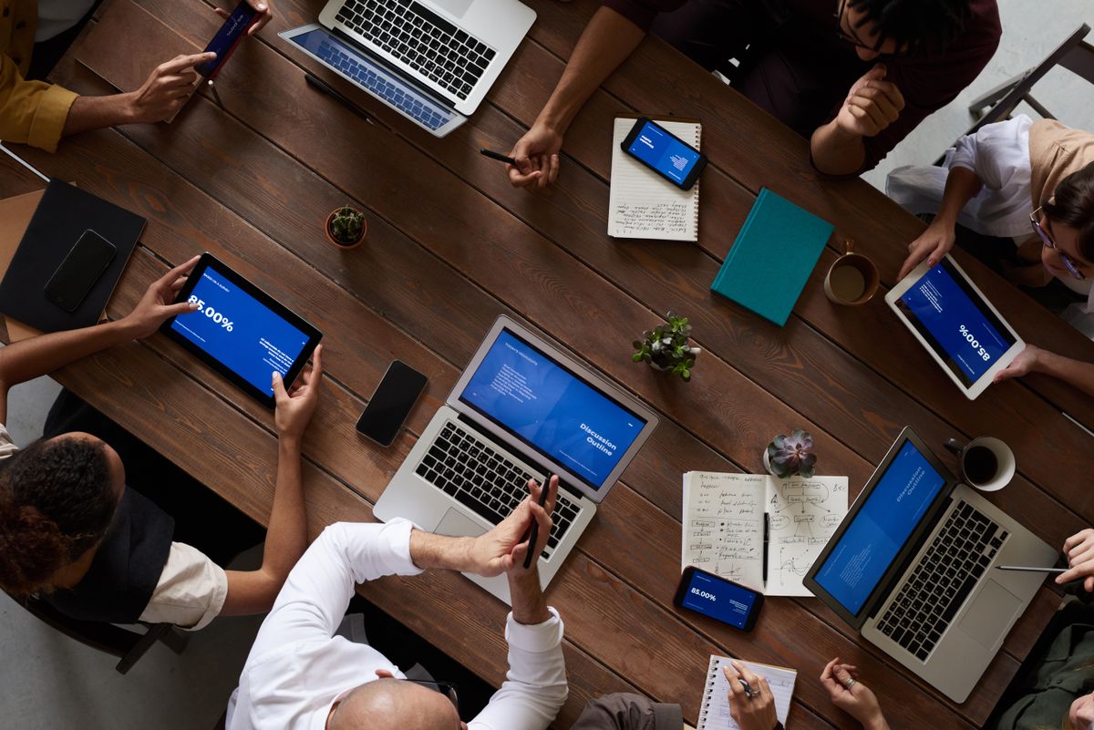 PR team having a strategy meeting around a table with laptops and notes