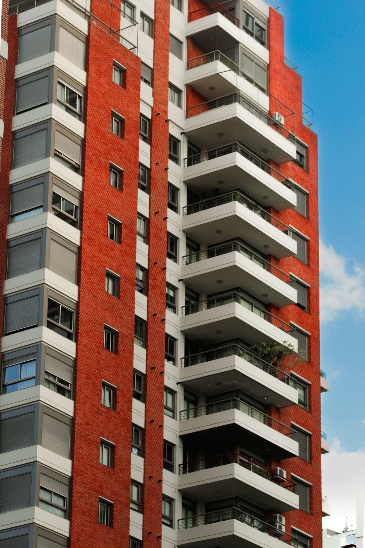 Red brick apartment block with balconies, the kind of tenement and modern flat stock a property manager oversees