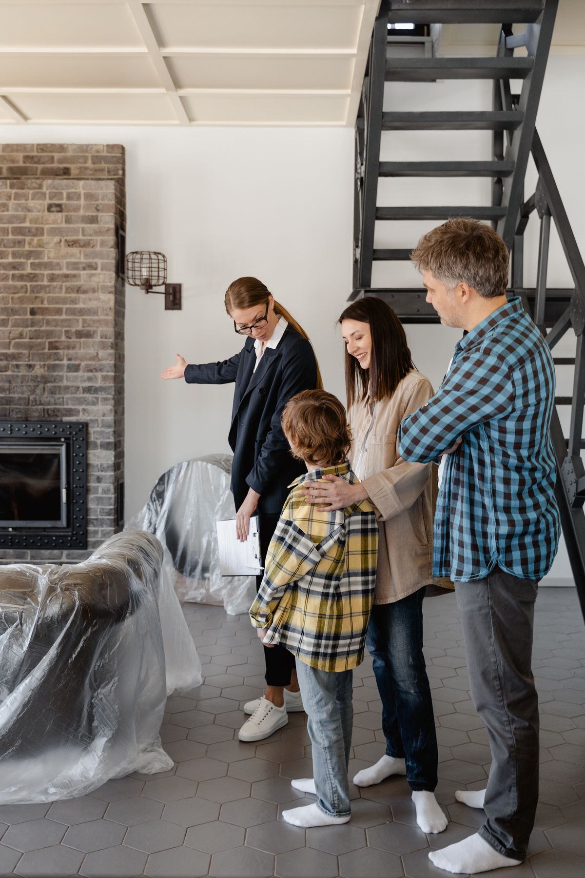 Real estate agent showing a living room to prospective buyers