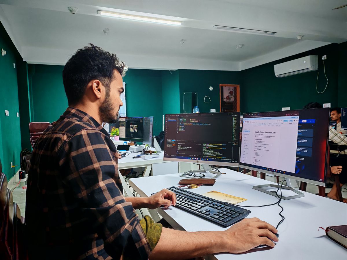 A SaaS engineer working across dual monitors in a modern, well-lit office