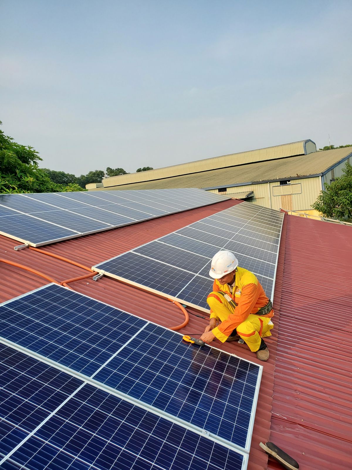 Solar installer securing a panel bracket during a rooftop installation