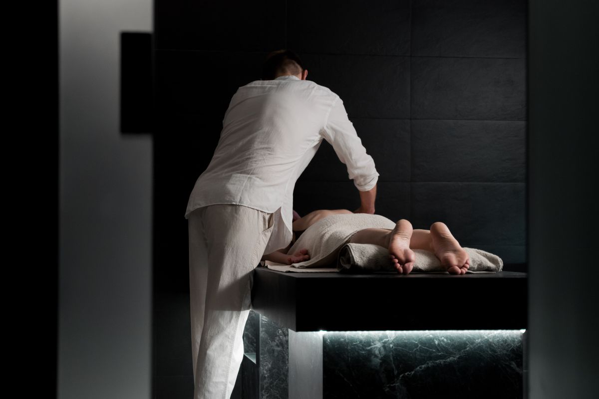 Therapist performing a relaxing massage treatment in a calm spa treatment room
