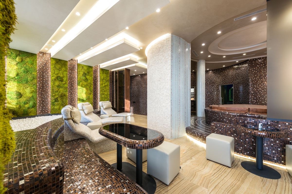 Modern luxury spa interior with loungers, mosaic tiling and soft ambient lighting