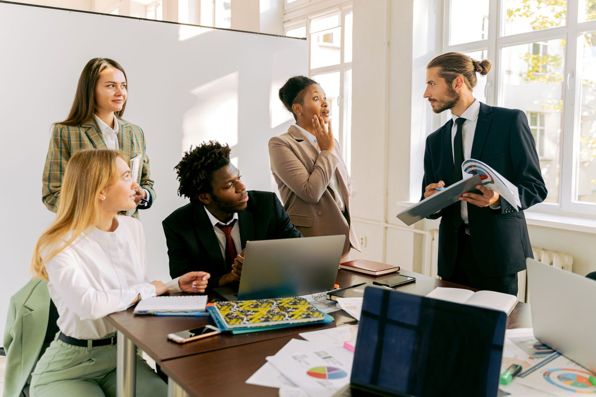 Staffing agency team reviewing candidate shortlists around a meeting table