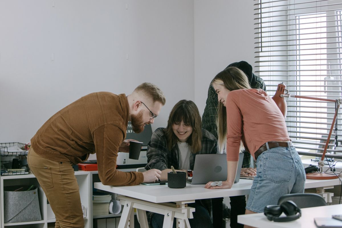 Early-stage startup team gathered around a desk reviewing metrics