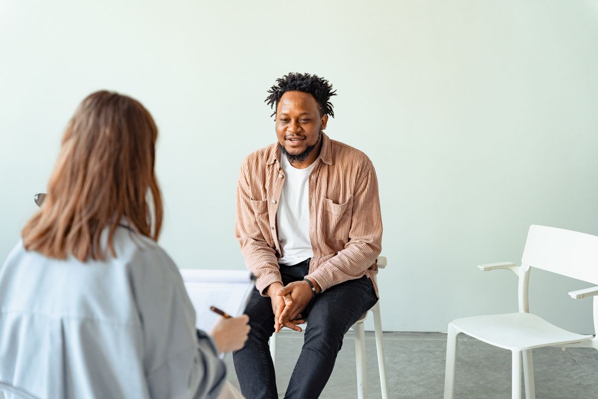 Counsellor in conversation with a client during a psychotherapy session in a modern practice room