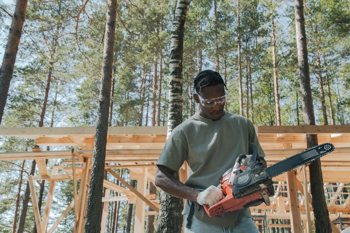 Tree surgeon holding a chainsaw ready to begin a tree removal job