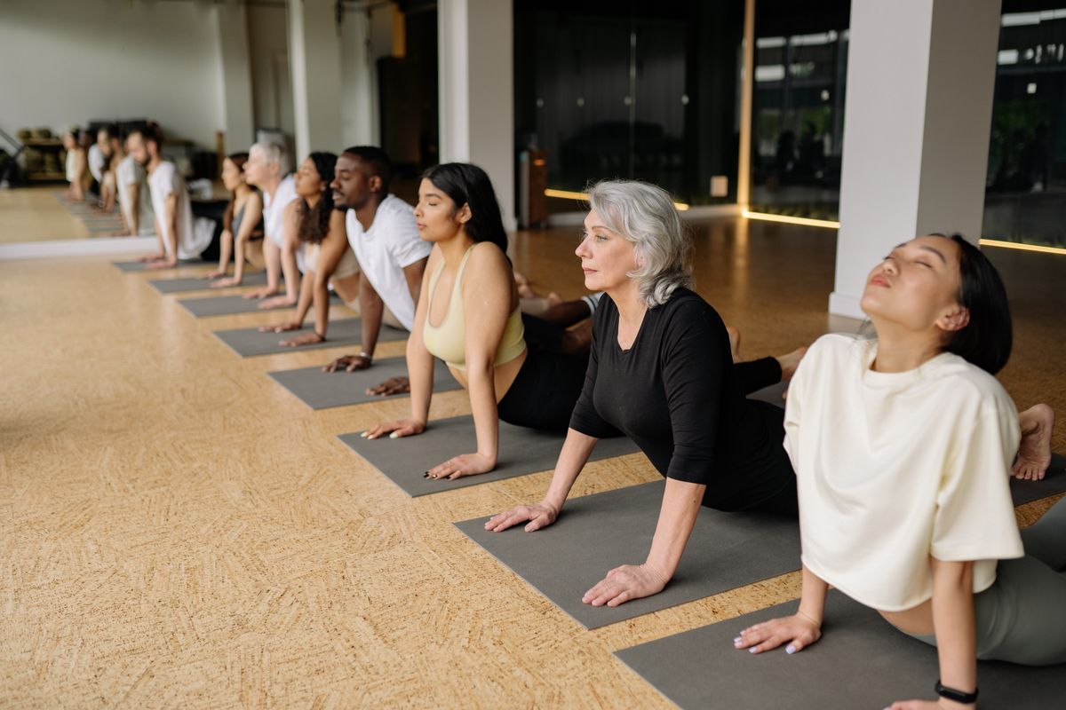 Yoga students holding a pose together during a guided studio class