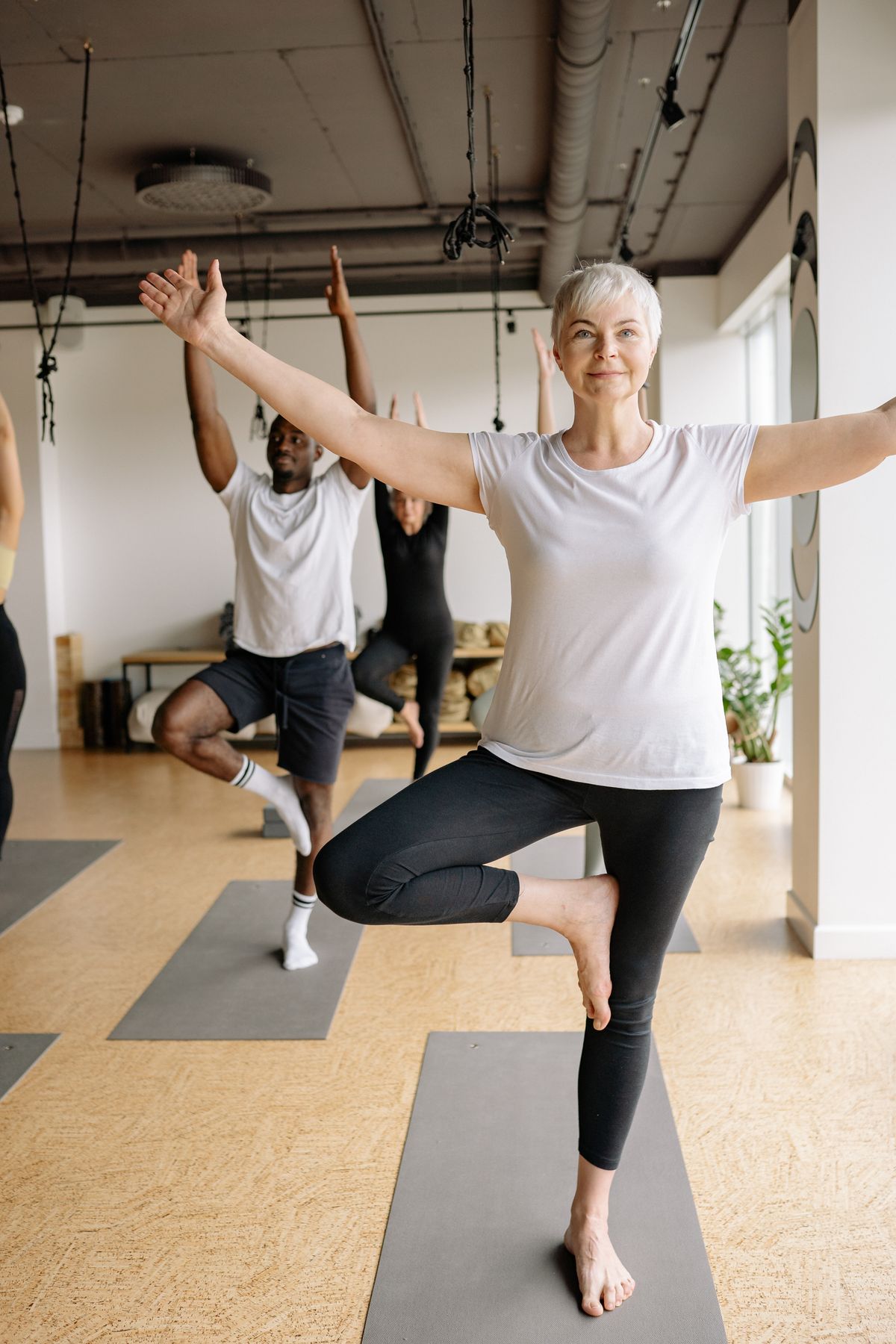 Older adult practising a seated yoga pose as part of an inclusive class